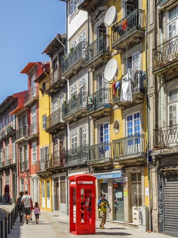 farbenfrohe Häuserfassade mit charakteristischer roter Telefonzelle in Porto