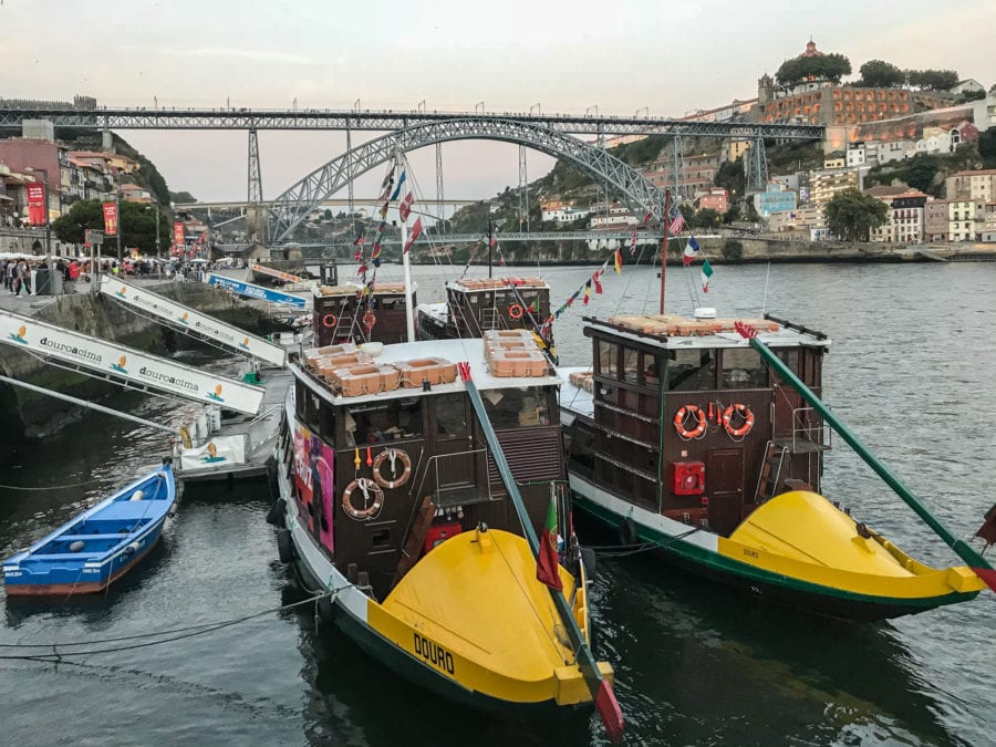 Gelbe Boote auf dem Douro mit Blick auf die Ponte Dom Luis I in Porto am Jakobsweg Portugal