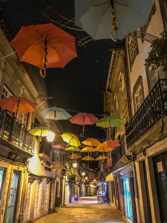Gasse mit hängenden Regenschirmen bei Nacht in Viana do Castelo