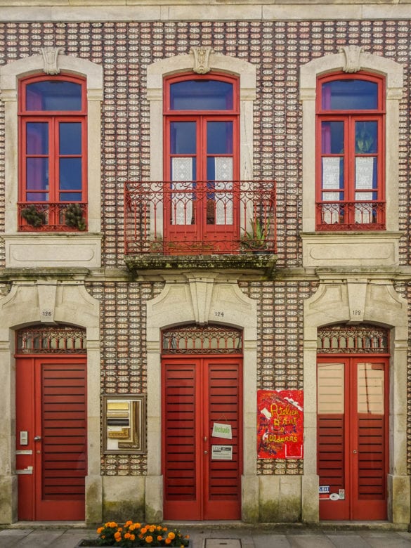 Hausfassade mit Fliesen und roten Fenstern in Caminha
