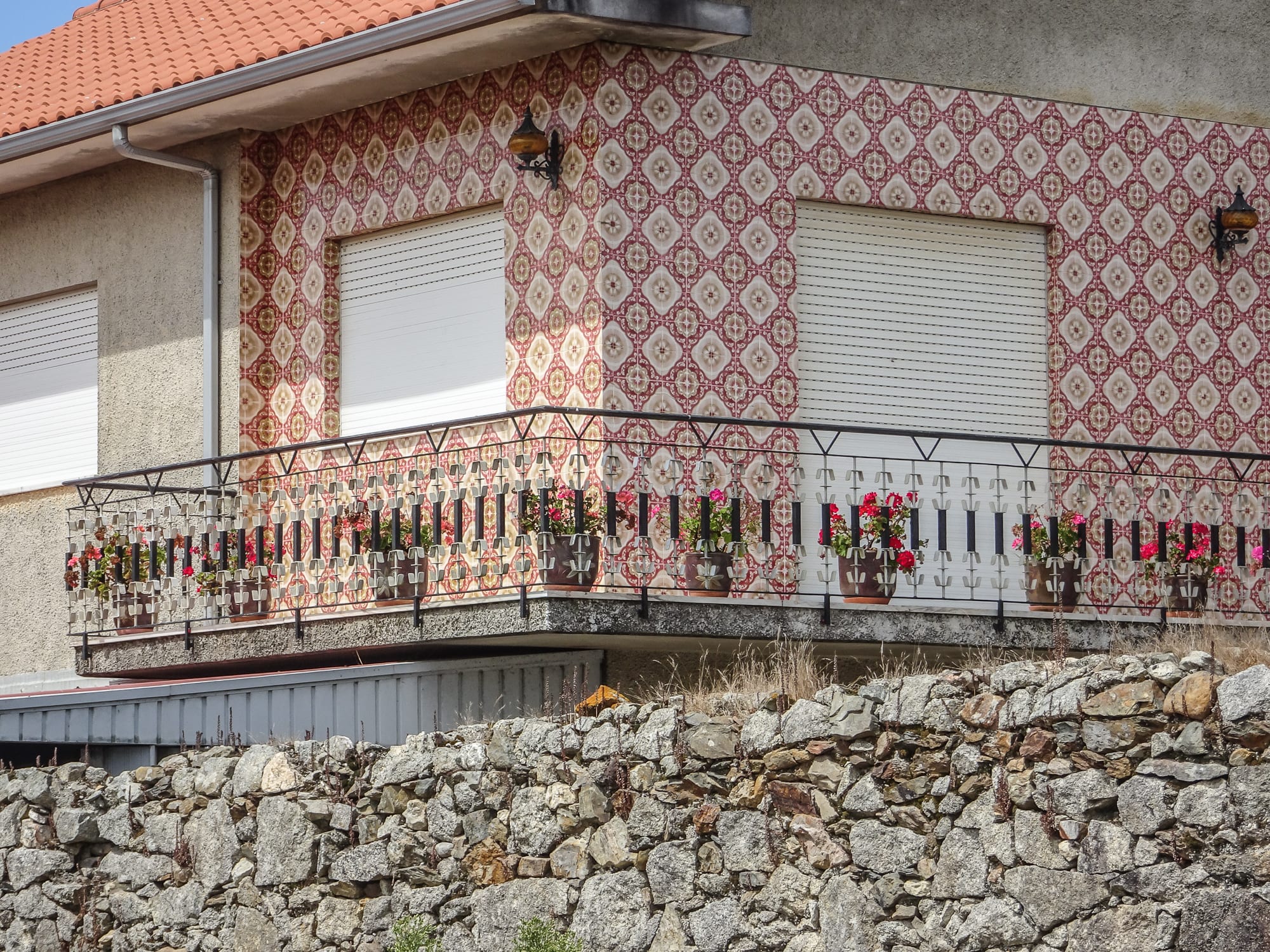 Haus mit rot-weißen Fliesen am Wegesrand