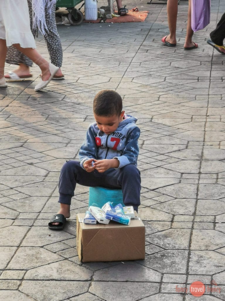 Kind verkauft Taschentücher auf dem Djemaa el-Fna in Marrakesch